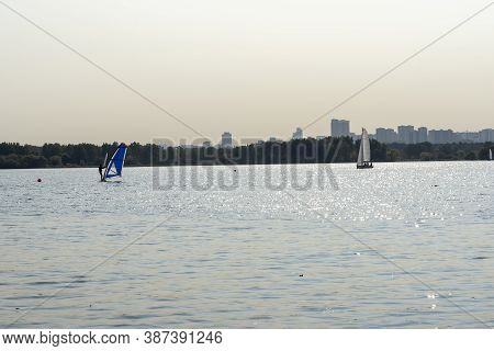 Windsurfer. Man Is Surfing On The Background Of Skyscrapers. Man On A Windsurf Board. Windsurfing In