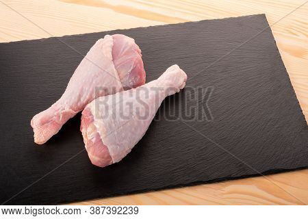Raw Turkey Legs On Black Slate Background. Closeup Two Raw Turkey Legs On Dark Stone Board. Wooden T