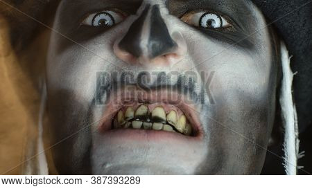Close-up Shot Of Creepy Man Face With Skeleton Makeup. Guy Making Faces, Trying To Scare, Opening Hi