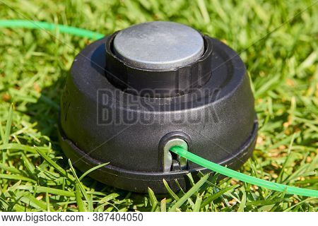 Coil Trimmer On The Grass, The New Coil For The Lawnmower Lies On A Grass With A Vein