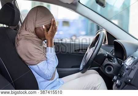 Stressed Black Muslim Woman Driver Sitting In Car, Covering Face With Hands, Having Accident, Failed