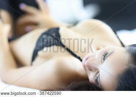 Woman In Bra Lies In Bed With Her Eyes Closed. Erotic Fantasies And Dreams Concept