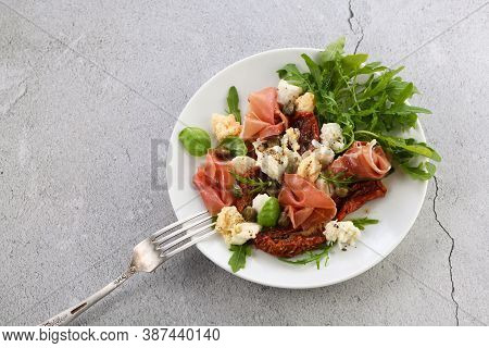 Salad Arugula, Parma Ham With Sun-dried Tomatoes, Mozzarella Slices, Croutons, Capers, Seasoned Oil 