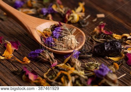 Healing Tea Made From Dried Flowers In A Wooden Spoon Close-up. Dried Flower Petals Close-up. Healin