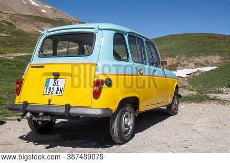 Col Du Galibier, France - July 8, 2020: An Oldtimer Renault 4 Car In Blue And Yellow Colors