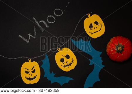 Halloween Background With Pumpkins And Bats Made Of Colored Paper. On A Black Background, Top View W