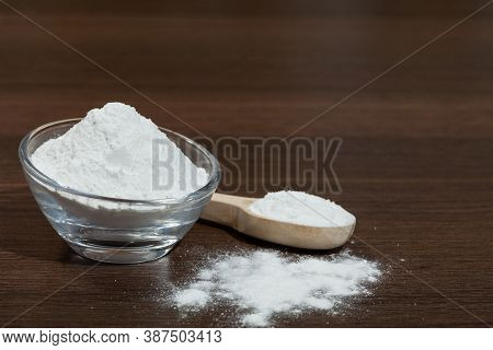 Baking Soda - Glass Bowl And Wooden Spoon With Baking Soda; On Dark Wooden Background.