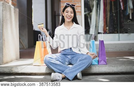 Asian woman sit rested after shopping in a colorful bag and she was happy to go shopping, Happy shop