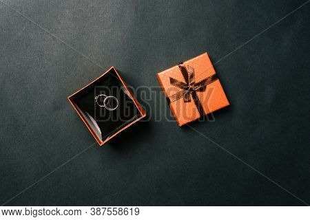 Wedding Rings In A Box On A Dark Background. Open Brown Box With The Bride And Grooms Rings. Wedding