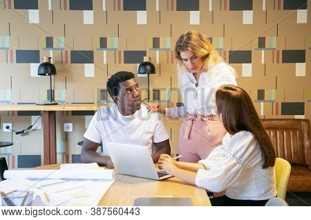 Designers Discussing Project With Team Leader. Manager Patting Shoulders Of Employee. Creative Profe