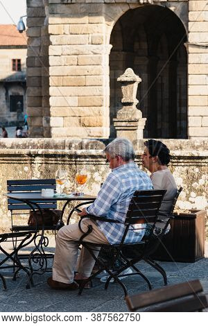 Santiago De Compostela, Spain - July 18, 2020: Unidentified Middle-aged Couple Enjoying A Glass Of W