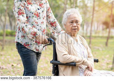 Asian Senior Or Elderly Old Lady Woman Smile Bright Face Patient On Wheelchair In Park.