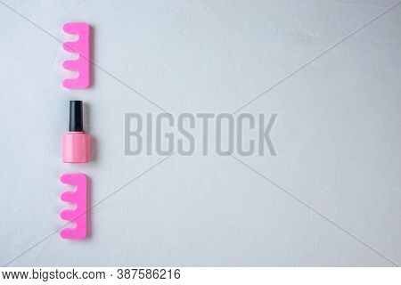 Bottle Of Pink Nail Polish And Toe Separators On A White Background On The Left. Minimal Set Of Tool