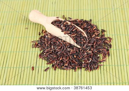 arroz preto com colher de madeira em esteira de bambu