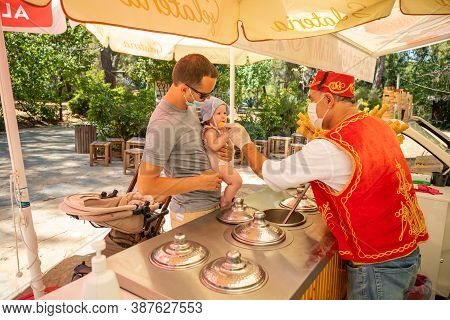 Antalya, Turkey - 4.09.2020: Seller Give Traditional Turkish Ice Cream To Man With Baby Girl In A Su