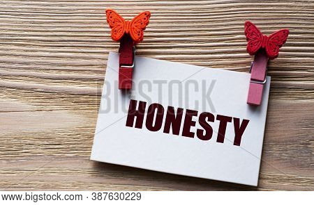 Honesty - Word On A White Sheet With Beautiful Clothespins On A Wooden Background. Technology And Ed