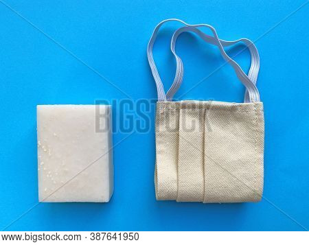 White Hand Soap And Surgical Face Mask On A Blue Backround