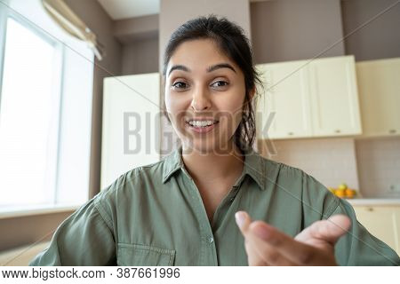 Young Indian Woman Speaking To Webcam During Conference Video Call Working At Home Office. Distance 