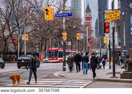 Toronto, Canada - 01 04 2020: Pedestrians Crossing The University Avenue At Queen Street With Old Ci
