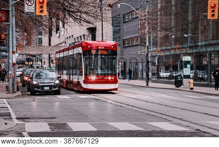 Toronto, Canada - 01 04 2020: A New Bombardier Made Streetcar And Cars Standing At Traffic Lights On