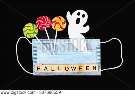 Cut Out Paper Ghost, Colorful Lollipops, Medical Mask And Word Halloween On Black. Halloween Backgro