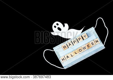 Cut Out Paper Ghost, Medical Mask And Words Happy Halloween On Black Background. Halloween Backgroun