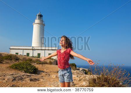 เด็กสาวเปิดมือให้ลมในประภาคารกว้างลาของ Formentera วันสีน้ำเงิน