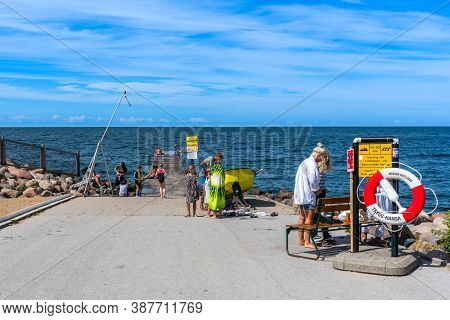 Visby, Sweden - July 27, 2020: Front View Of Children And Adults Bathing In The Baltic Sea Ocean Fro