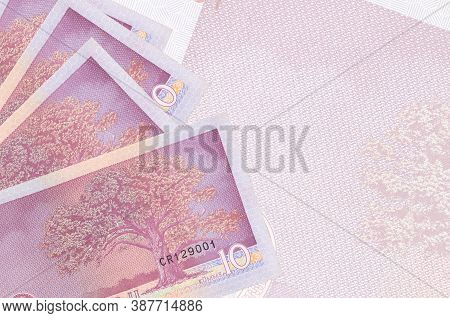 10 Estonian Kroon Bills Lies In Stack On Background Of Big Semi-transparent Banknote. Abstract Busin