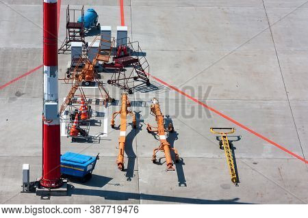 Towbars For Different Airplanes, Aircraft Steps And Signal Cones At The Airport Apron