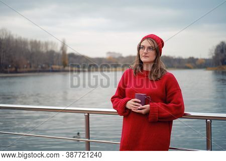 Adult Woman By The Autumn River With A Cup Of Coffee In Her Hands, Lifestyle