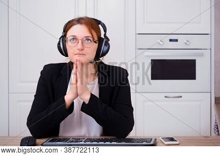 A Woman Prays To God At A Computer During Isolation Due To A Coronavirus. Religion And Confession In