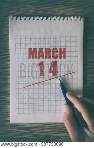 March 14th. Day 14 Of Month, Close Up Of Human Hand With Pen On Notepad With Red Underlined Date.  S