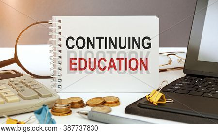Desktop With Documents, Calculator And Notebook. On A Blockboard Inscription Continuing Education