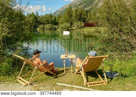 People Drinking In A Beach Bar Of The Lake At Tasch On The Swiss Alps