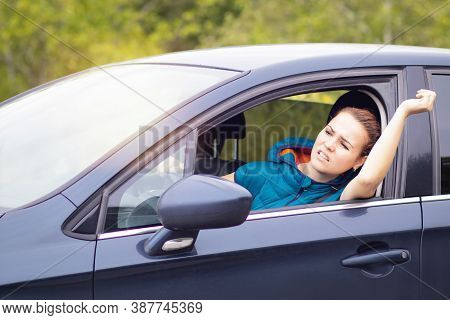 Angry Aggressive Woman, Female Emotional Annoyed Driver Shouts, While Driving A Car, Waving Her Hand