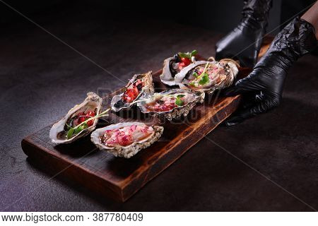 Two Types Of Oysters With Savory Sauces On A Wooden Board. Stylish Serving Dishes. Oyster Season. Un