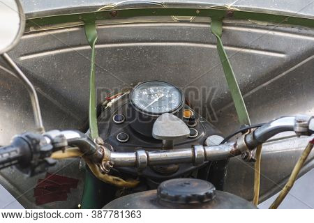 Control Panel Of An Old And Rusty Green Motorcycle. Old Analog Speedometer And Switches On The Headl