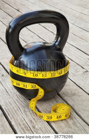 kettlebell e Flessometro sul ponte in legno - concetto di dieta e fitness