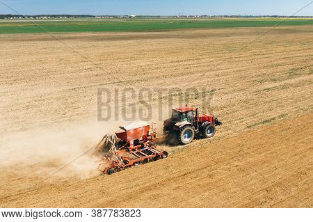 Aerial View. Tractor With Seed Drill Machine Sowing The Seeds For Crops In Spring Season. Beginning 