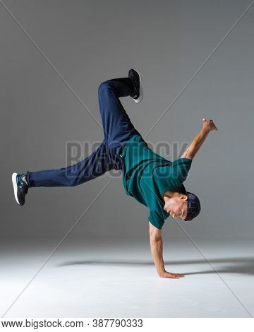 Cool Guy Breakdancer Dance On The Floor Isolated On Gray Background. Breakdance Lessons
