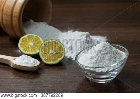 Baking Soda - Sodium Bicarbonate And Lemon; On Dark Wooden Background.