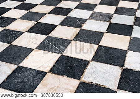 Black And White Checkerboard Tiles, Old With Scratches And Scuffs.