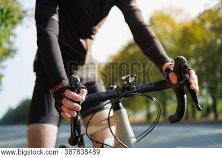 Hands Of A Cyclist Resting On Road Bike Handlebars. Cycling, Bicycle Sport Training Outdoors