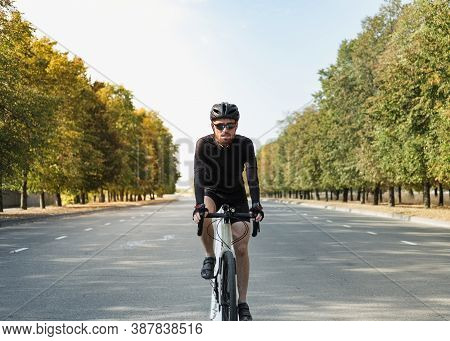 Portrait Of A Man On A Gravel Bike On The Road. Well Equipped Cyclist Riding A Modern Bicycle Outdoo