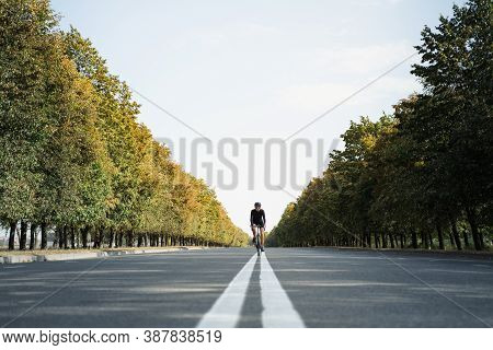 Man Rides A Gravel Bike In The Middle Lane Of The Road. Well Equipped Cyclist On A Modern Bicycle Ou