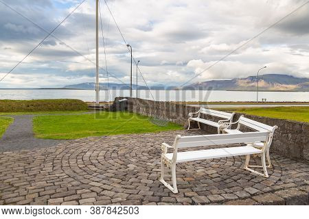 White Benches In The Square. View Of Faxafloi Bay And Mountains, Reykjavik, Iceland.