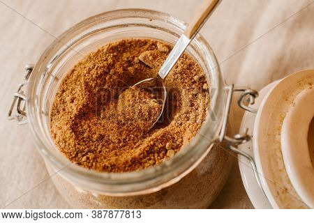 Panela Sugar Background. Close Up View Of Raw Cane Sugar In A Jar.