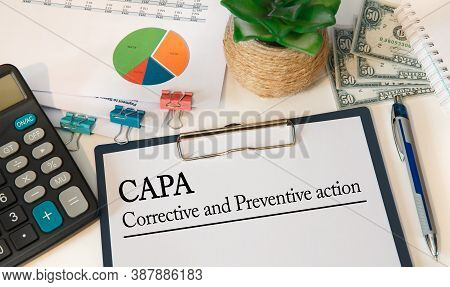Paper With Corrective And Preventive Action Capa On The Table, Calculator And Money