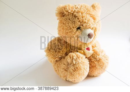 Soft Teddy Bear With Long Light Brown Fur And A Red Heart On A Scarf Around His Neck. Valentine\'s D